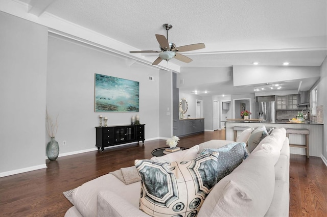 living room featuring a textured ceiling, dark wood-type flooring, ceiling fan, and lofted ceiling with beams