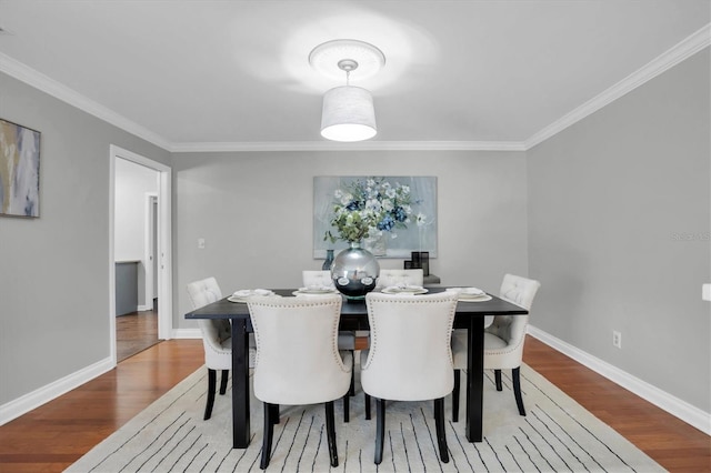 dining area featuring hardwood / wood-style flooring and ornamental molding