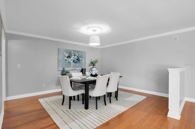 dining area featuring crown molding and hardwood / wood-style flooring