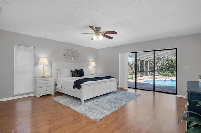 bedroom featuring ceiling fan, access to exterior, hardwood / wood-style floors, and a textured ceiling