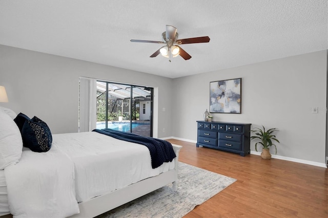 bedroom featuring ceiling fan, access to outside, a textured ceiling, and hardwood / wood-style flooring