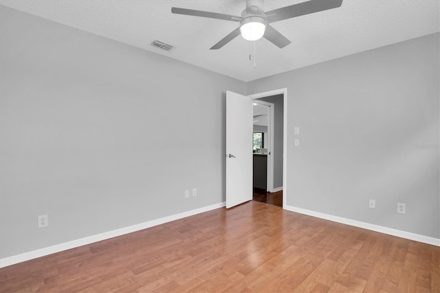 unfurnished room featuring ceiling fan, wood-type flooring, and a textured ceiling