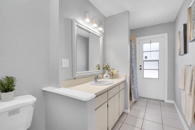 bathroom featuring toilet, tile patterned flooring, a shower with curtain, and vanity