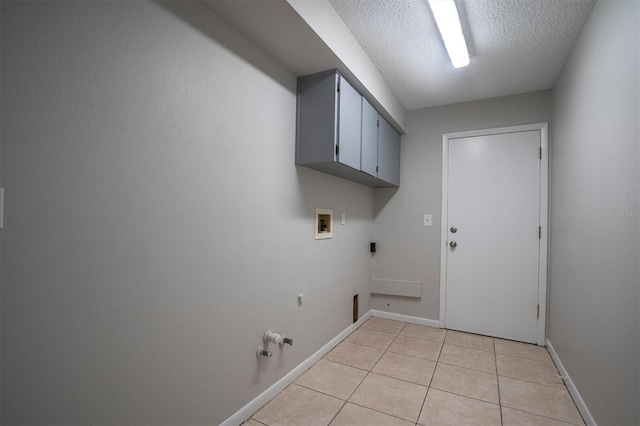 washroom with light tile patterned flooring, hookup for a washing machine, a textured ceiling, hookup for an electric dryer, and cabinets