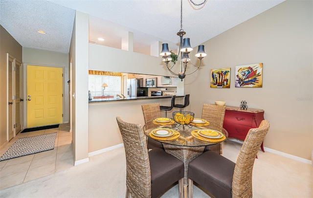 dining room with a chandelier, light tile patterned floors, and a textured ceiling