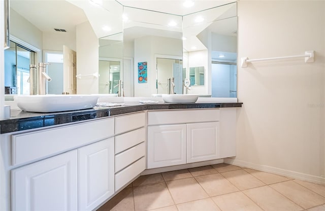 bathroom featuring tile patterned flooring, vanity, and a shower with shower door