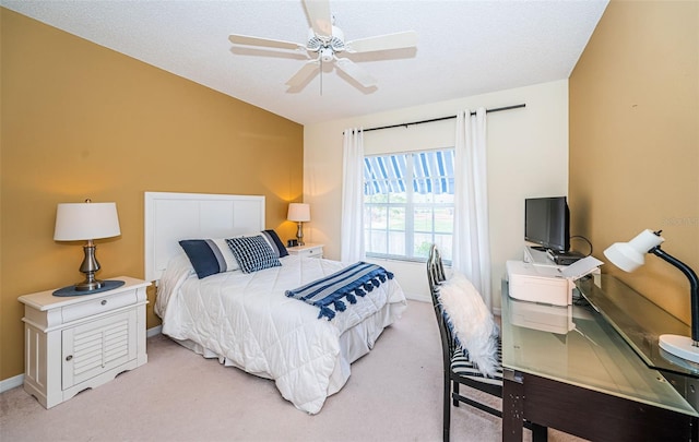 carpeted bedroom featuring ceiling fan and a textured ceiling