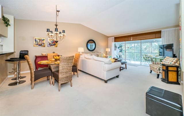 carpeted living room featuring vaulted ceiling and an inviting chandelier