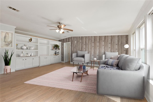 living room with ceiling fan, light hardwood / wood-style floors, and crown molding