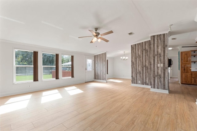 unfurnished living room with ceiling fan with notable chandelier, light hardwood / wood-style flooring, and ornamental molding