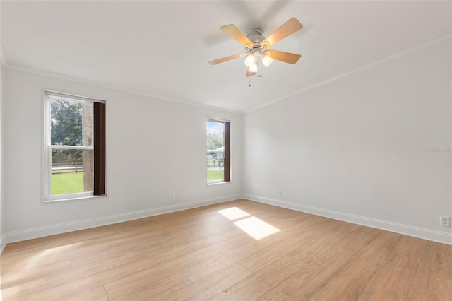 spare room featuring a healthy amount of sunlight, light wood-type flooring, and ornamental molding