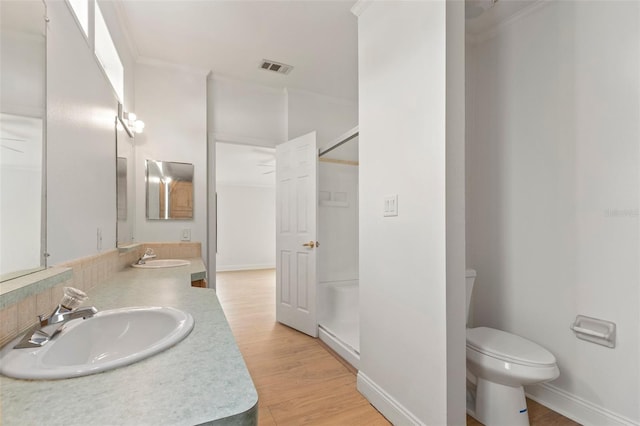 bathroom with hardwood / wood-style floors, vanity, ornamental molding, and toilet