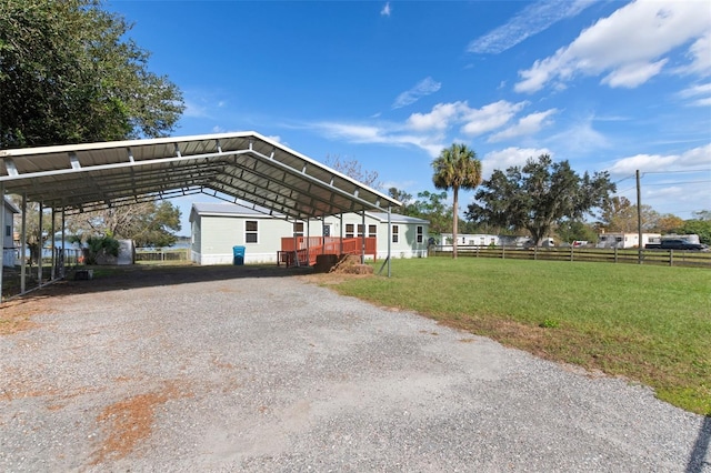 view of side of property featuring a carport and a lawn