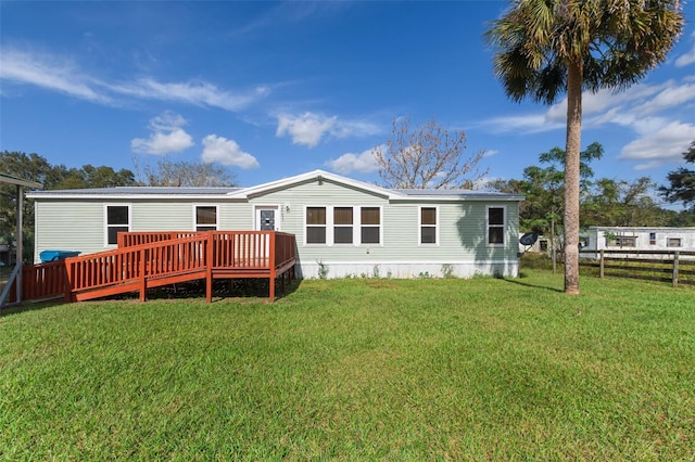 rear view of house with a lawn and a deck