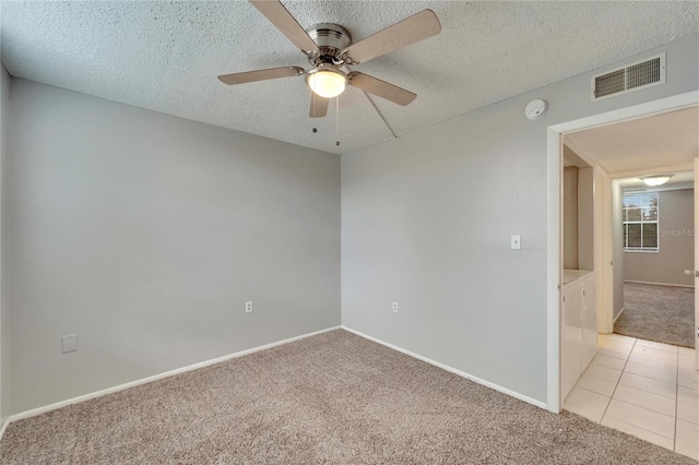 carpeted empty room with a textured ceiling and ceiling fan