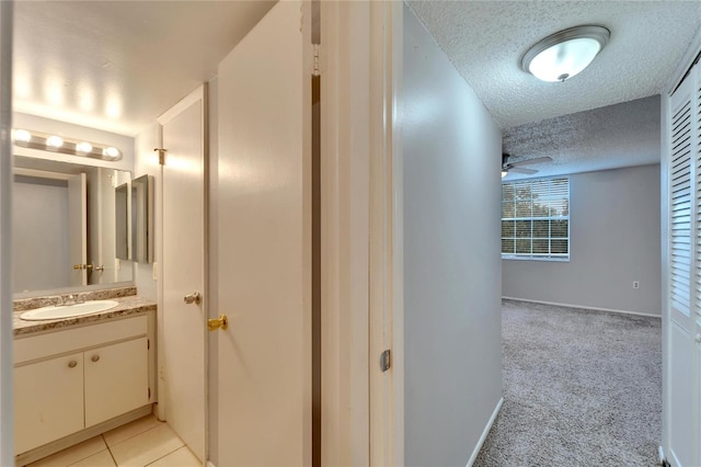 107 Caldwell Dr Unit 291, Brandon, FL 33510 - hallway with a textured ceiling, a sink, baseboards, and light colored carpet