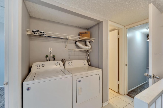 laundry area with light tile patterned flooring, independent washer and dryer, and a textured ceiling