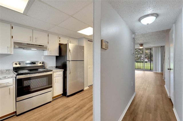 kitchen with ceiling fan, white cabinets, light wood-type flooring, and appliances with stainless steel finishes