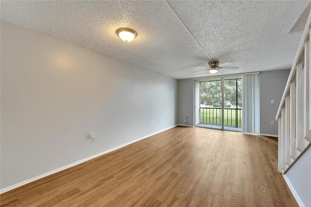 unfurnished room featuring ceiling fan, wood-type flooring, and a textured ceiling