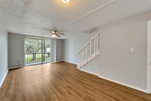 107 Caldwell Dr Unit 291, Brandon, FL 33510 - spare room featuring a ceiling fan, a textured ceiling, stairs, baseboards, and wood finished floors
