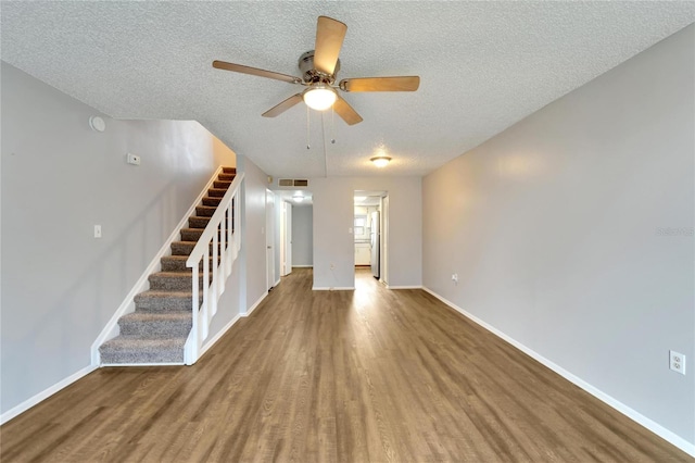 unfurnished living room with ceiling fan, wood-type flooring, and a textured ceiling