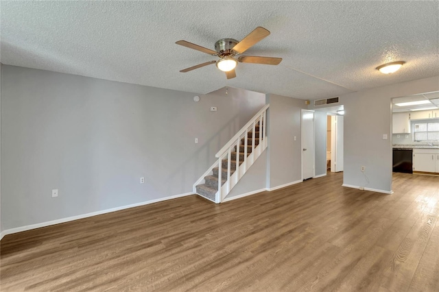107 Caldwell Dr Unit 291, Brandon, FL 33510 - unfurnished living room with stairs, a textured ceiling, wood finished floors, a ceiling fan, and baseboards
