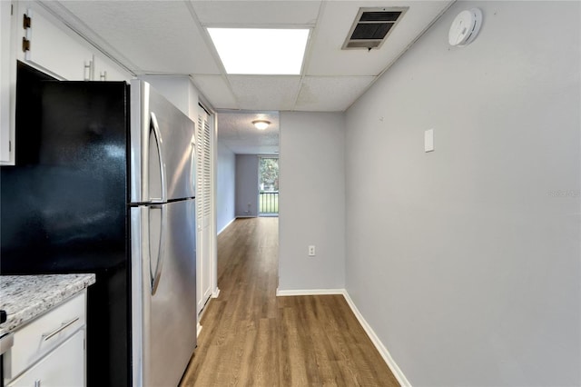 107 Caldwell Dr Unit 291, Brandon, FL 33510 - kitchen with freestanding refrigerator, light wood-style flooring, white cabinets, baseboards, and a drop ceiling