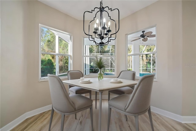 dining area featuring ceiling fan with notable chandelier, a healthy amount of sunlight, and light hardwood / wood-style flooring