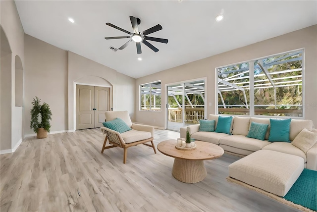 living room with ceiling fan, light hardwood / wood-style floors, lofted ceiling, and a wealth of natural light