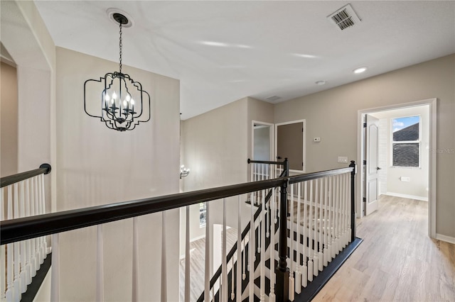 corridor with a chandelier and light hardwood / wood-style flooring