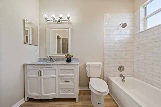 full bathroom featuring tiled shower / bath combo, toilet, wood-type flooring, and vanity