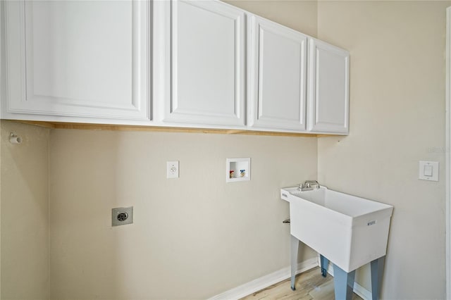 clothes washing area featuring hookup for an electric dryer, cabinets, hookup for a washing machine, and light hardwood / wood-style flooring