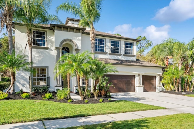 mediterranean / spanish-style house with a garage and a front lawn