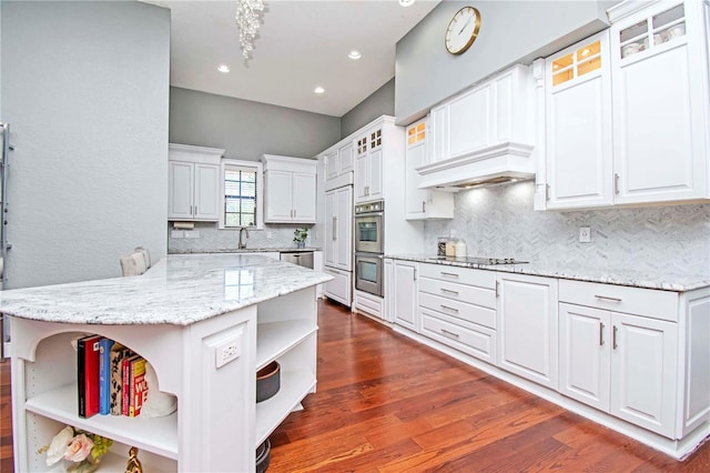 kitchen featuring white cabinets, black electric stovetop, light stone countertops, and kitchen peninsula