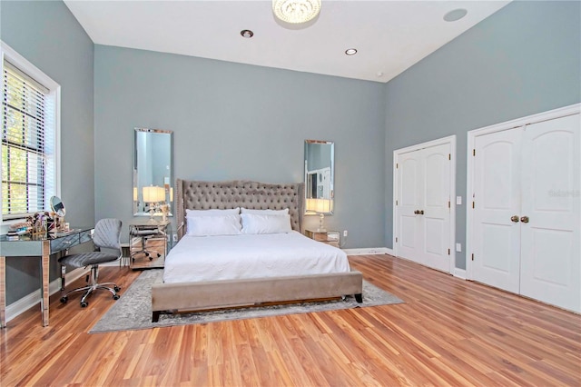 bedroom featuring multiple closets and light hardwood / wood-style flooring