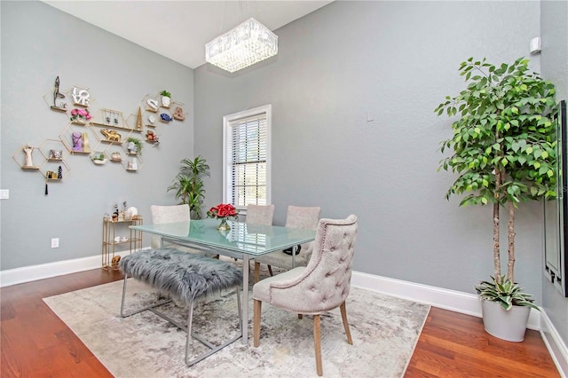 dining space featuring dark hardwood / wood-style floors and a chandelier