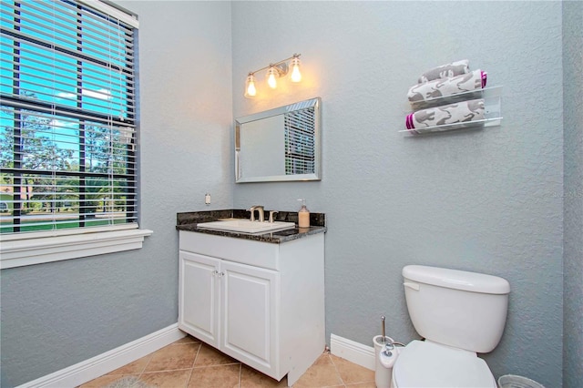 bathroom with tile patterned flooring, vanity, and toilet