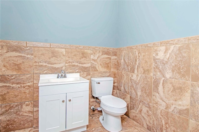 bathroom with vanity, tile walls, and toilet