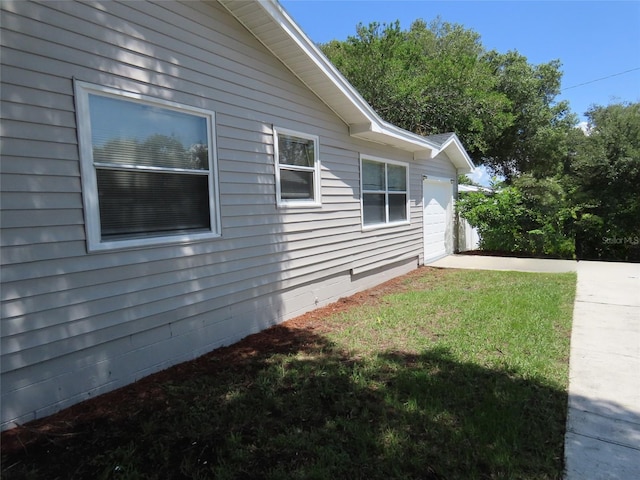 view of home's exterior with a lawn and a garage