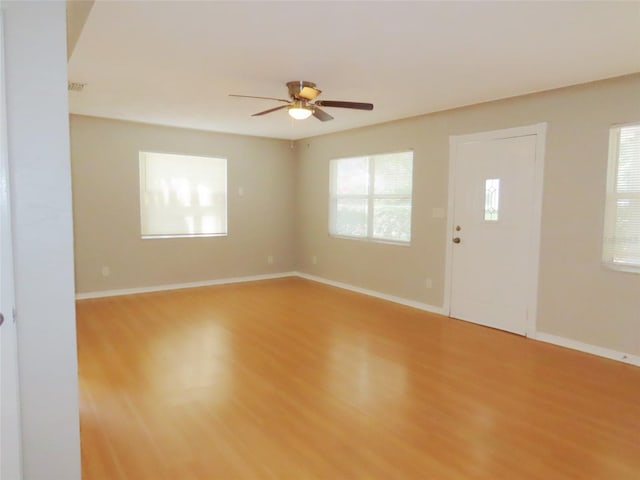 unfurnished room featuring light wood-type flooring, ceiling fan, and a healthy amount of sunlight