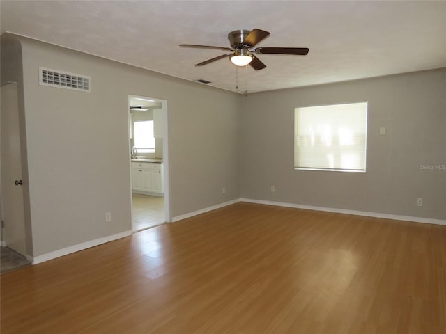 spare room featuring ceiling fan, light hardwood / wood-style floors, and sink