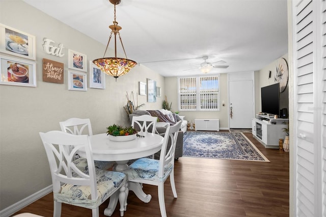 dining space with ceiling fan and dark hardwood / wood-style flooring