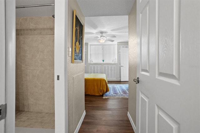 corridor featuring a textured ceiling and dark wood-type flooring