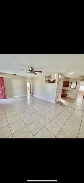 tiled empty room featuring ceiling fan