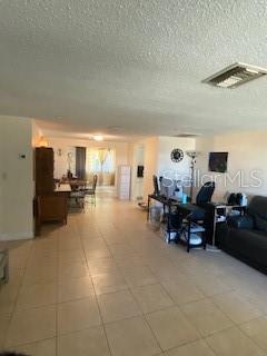 living room with tile patterned floors and a textured ceiling