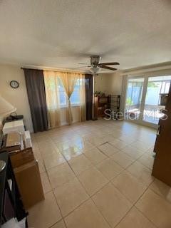 8906 Windsong Ln, Port Richey, FL 34668 - living area with a ceiling fan and light tile patterned floors