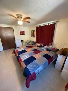 8906 Windsong Ln, Port Richey, FL 34668 - tiled bedroom featuring a textured ceiling and a ceiling fan