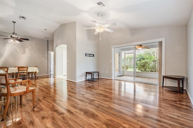 living room with hardwood / wood-style flooring, ceiling fan, and lofted ceiling