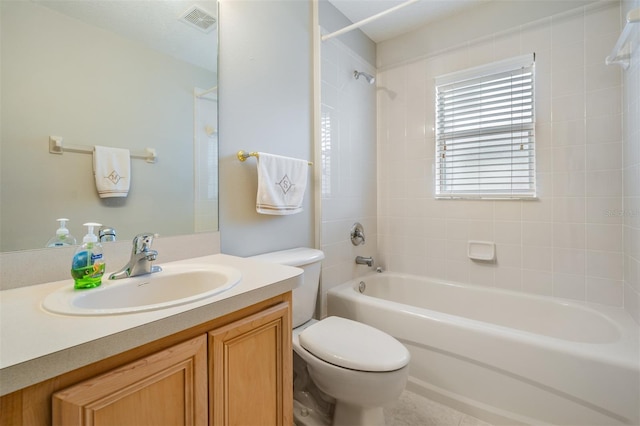 full bathroom featuring tiled shower / bath combo, toilet, and vanity