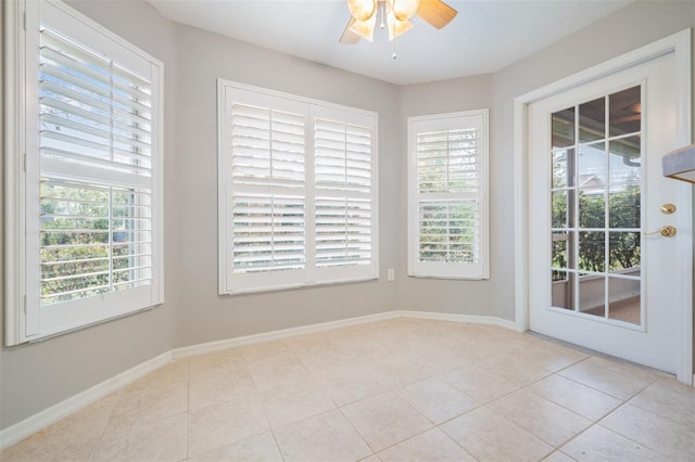 tiled empty room with plenty of natural light and ceiling fan